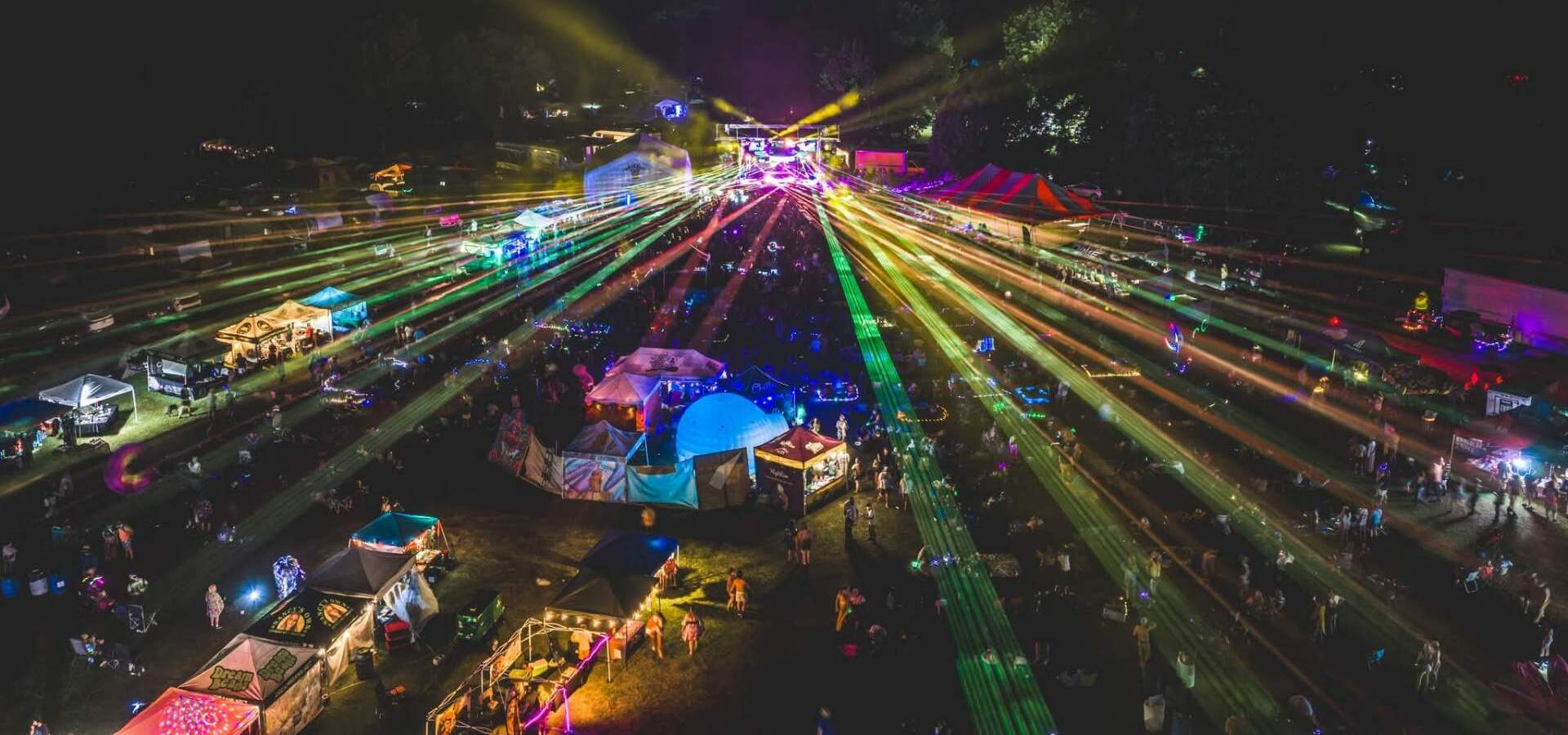 Lasers fanning over a festival field at night